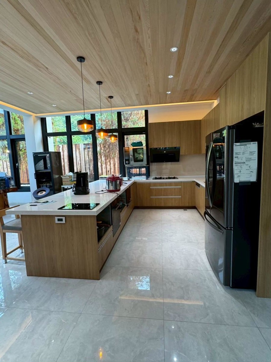 九十度木紋系統廚具,木質天花搭中島吧檯與高腳椅